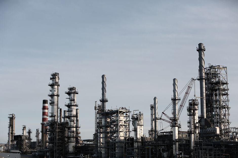 Skyline view of an industrial factory with tall chimneys against a clear sky.