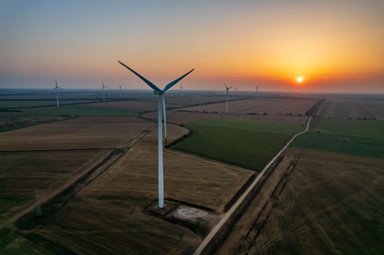 Aerial view of wind turbines at sunset in Durankulak, Bulgaria, showcasing renewable energy.