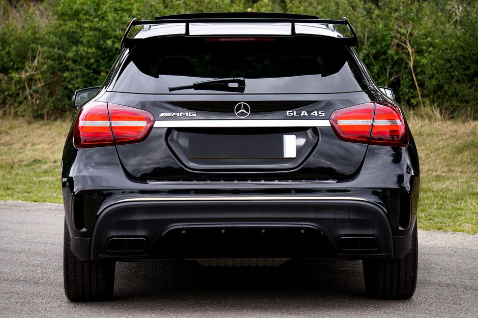 Rear view of a black Mercedes-Benz GLA 45 AMG parked outdoors, showcasing luxury and style.