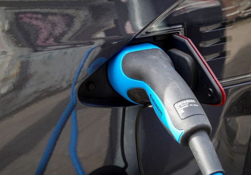 Close-up of an electric vehicle being charged using a Mennekes EV connector.