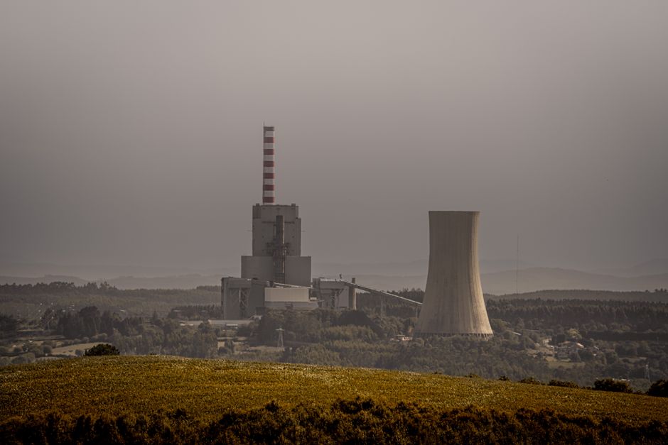 A coal-fired power plant emits smoke on an overcast day, highlighting energy and environmental issues.