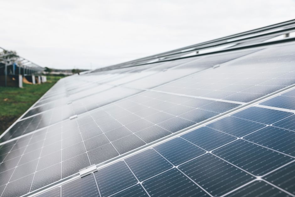 Detailed close-up shot of solar panels at an outdoor solar farm under clear sky.
