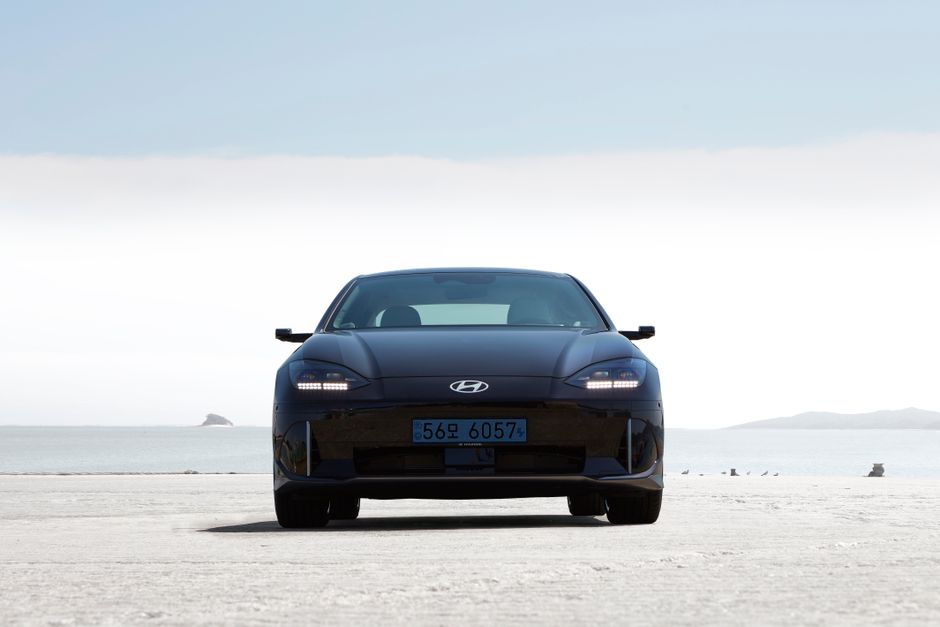 Front view of a black Hyundai Ioniq 6 parked against a serene coastal backdrop.