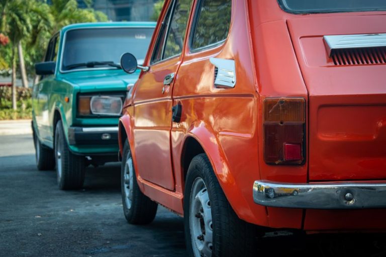 Vintage Fiat 126p and Lada in bright colors parked outdoors, classic appeal.