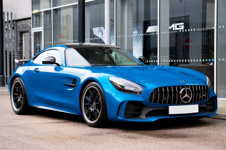 Blue Mercedes-AMG GT R outside automotive showroom. Modern design and luxury.