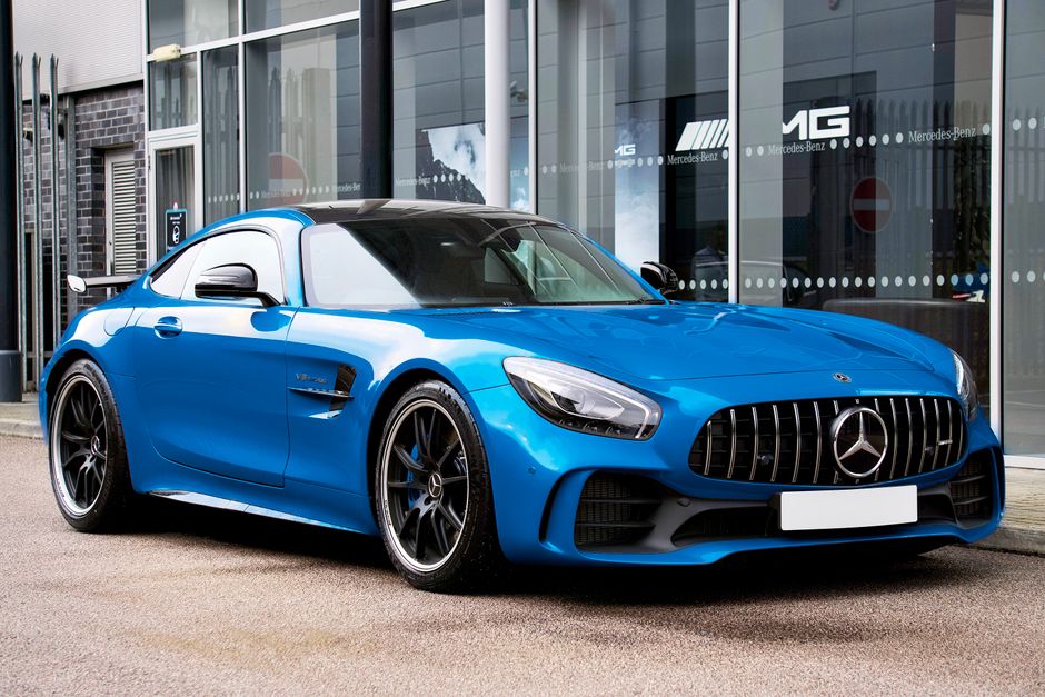 Blue Mercedes-AMG GT R outside automotive showroom. Modern design and luxury.