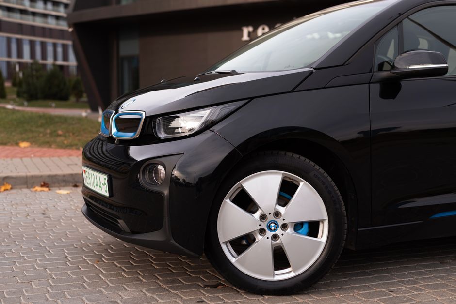 Detailed shot of a black electric BMW car parked in an urban area.