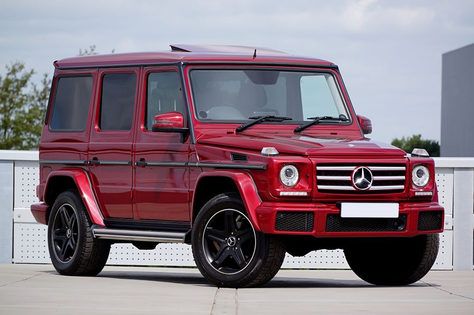 Red Mercedes-Benz G-Class SUV parked in an outdoor lot, showcasing luxury design and style.