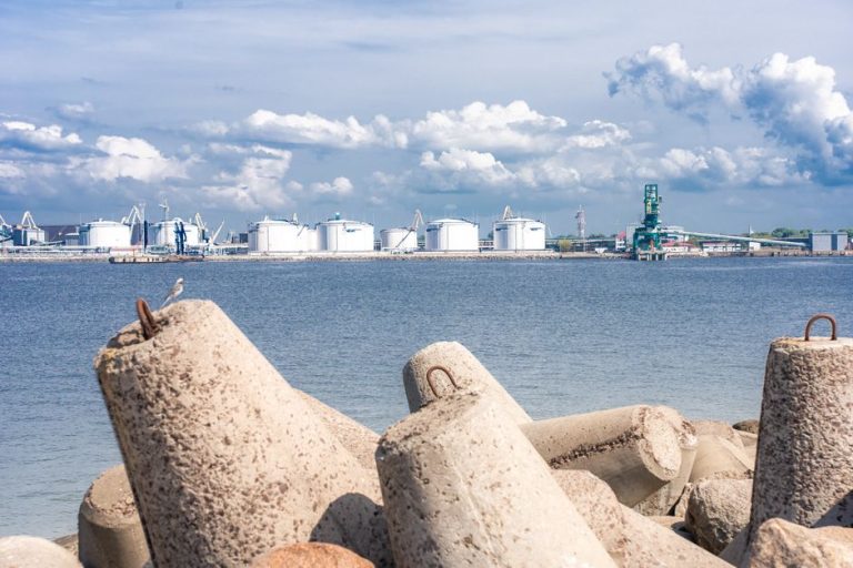 View of an industrial port and concrete wavebreakers on a sunny day in Ventspils, Latvia.