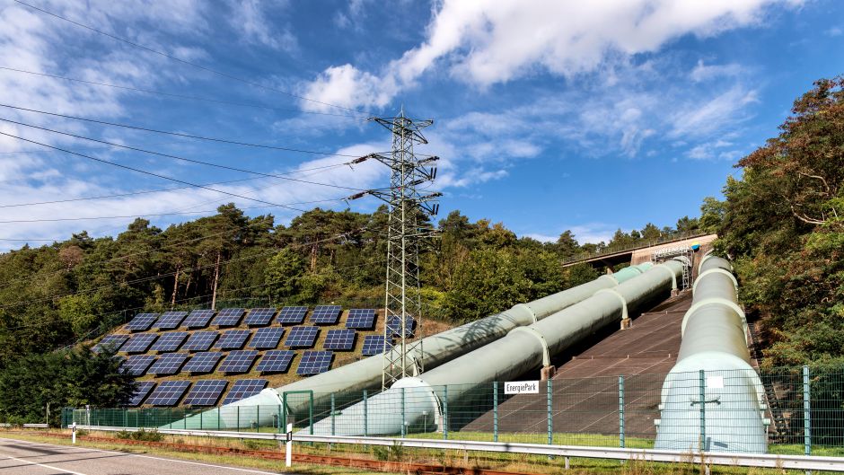 Solar panels and industrial pipes in Geesthacht's EnergiePark on a sunny day.