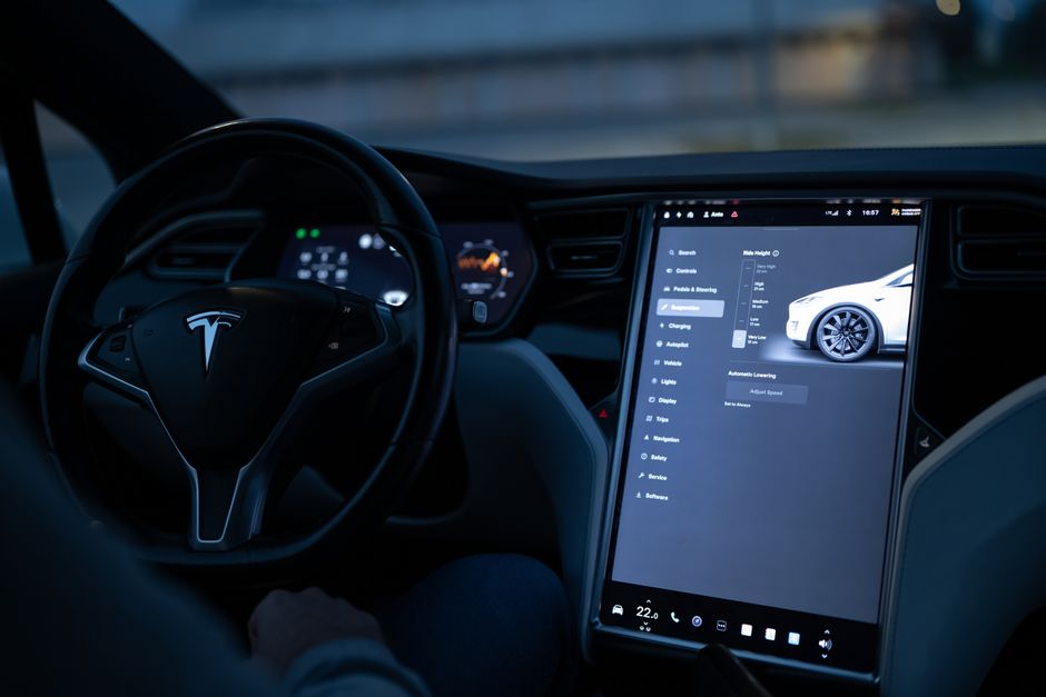 Tesla car interior showcasing advanced touchscreen display and steering controls.