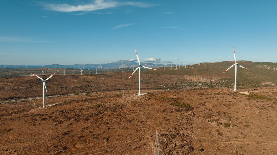 Aerial view of wind turbines in Çeşme, Türkiye, showcasing renewable energy in an arid landscape.
