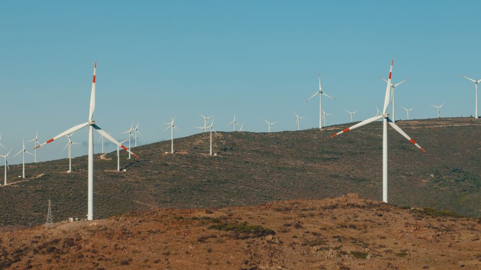 A scenic view of wind turbines on a hill in Çeşme, İzmir, Türkiye, harnessing wind energy efficiently.