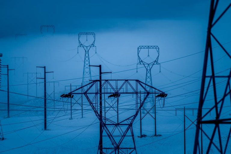Transmission towers in snowy East Wenatchee, WA, during winter, showcasing electrical infrastructure.