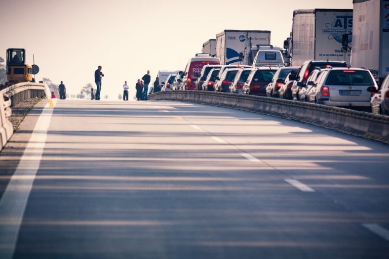 A congested highway with cars and trucks in a traffic jam during daylight.