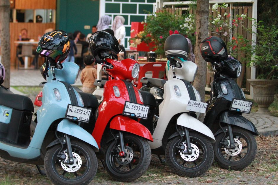 Vibrant scooters lined up with helmets, capturing an outdoor scene with a lively ambiance.