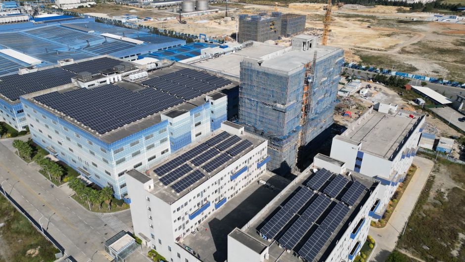 Aerial shot of industrial buildings with solar panels showcases sustainable energy.