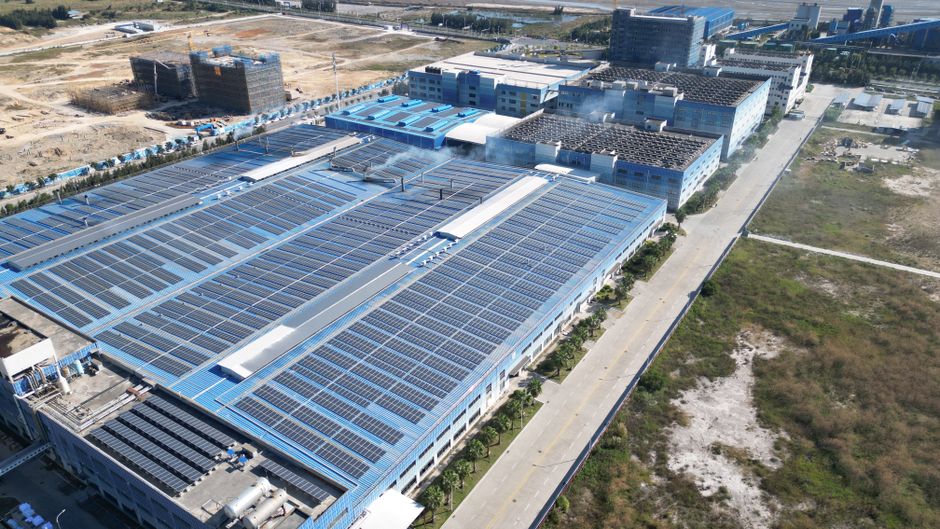 Aerial photograph showcasing large solar panels installed on an industrial building complex.