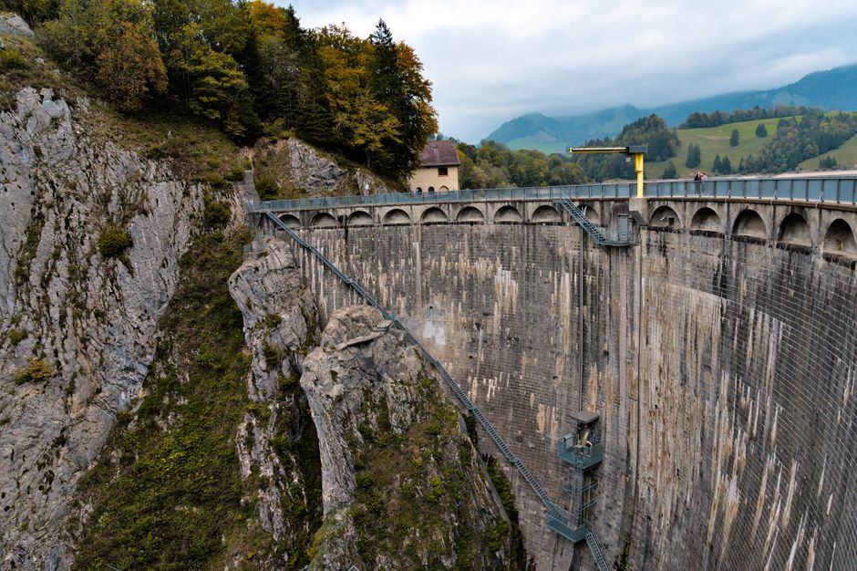 A stunning view of Emosson Dam in Switzerland surrounded by lush mountains and rich autumn hues.