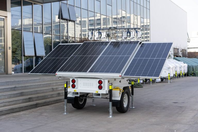 A mobile solar panel trailer parked outdoors by a modern building, showcasing renewable energy technology.