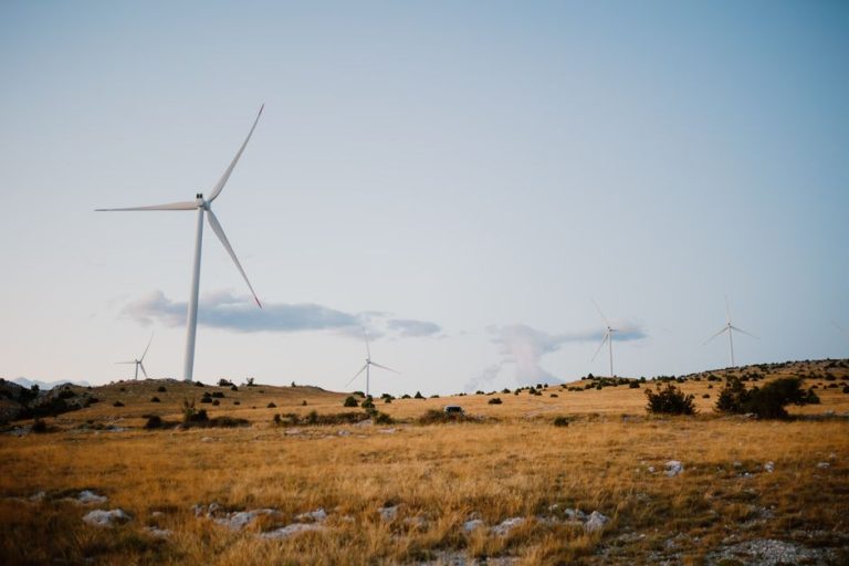 Wind turbines on a serene field in Mostar, showcasing clean energy.