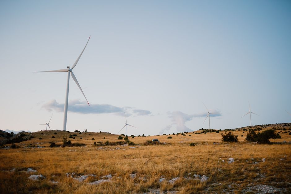 Wind turbines on a serene field in Mostar, showcasing clean energy.