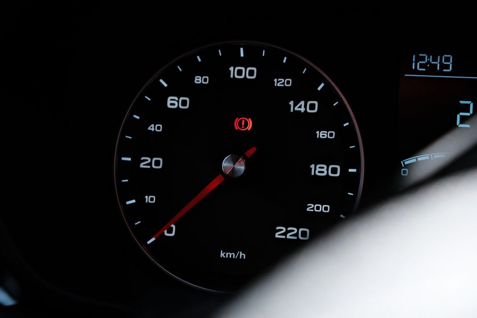Detailed view of a car speedometer showing speed in km/h with a warning light
