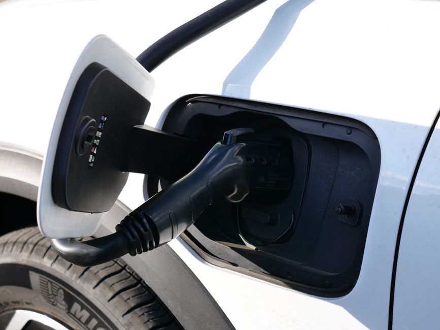 Close-up view of an electric vehicle charging with a focus on the connector and charging port.