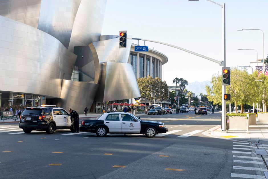 Daytime view of Los Angeles street intersection near Walt Disney Concert Hall with police cars present.