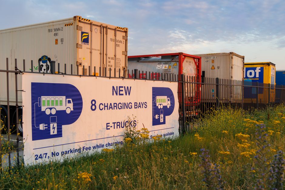 Electric truck charging station at sunset in Rotterdam showcasing sustainable transport.