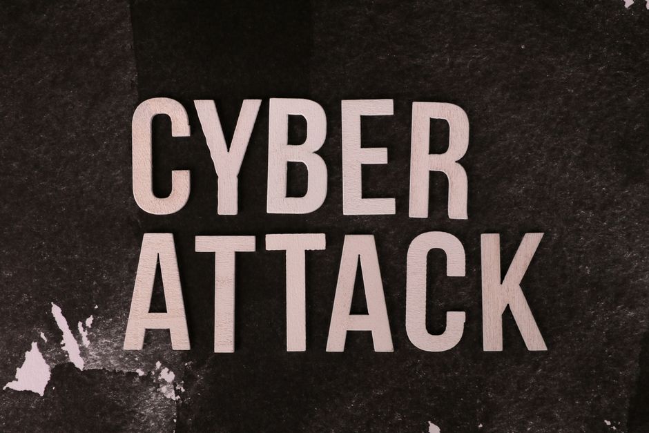 Text 'Cyber Attack' on textured dark paper highlights digital security threat concept.