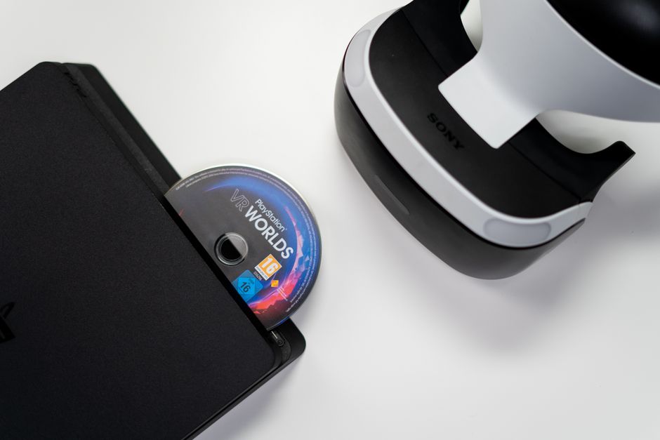 Overhead view of PlayStation console, VR headset, and game disc on a white background.