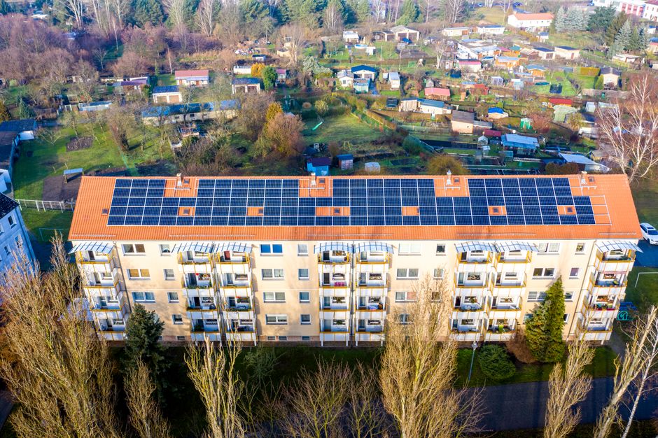 Aerial view of apartment complex with solar panels on rooftop in Beeskow, Germany.