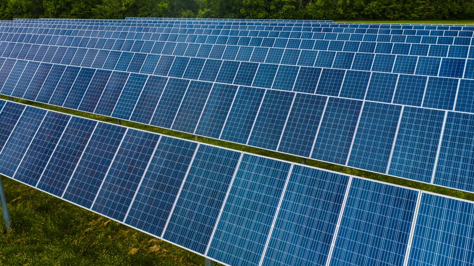 High angle pole mounted solar energy trackers installed on green field in solar power station