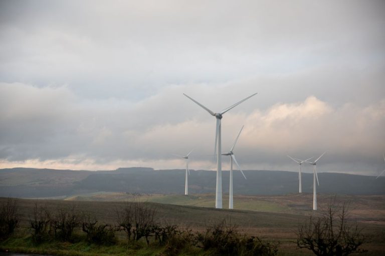 Majestic wind turbines in the serene UK countryside generate renewable energy.