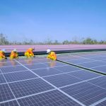 Workers installing solar panels on a sunny day, promoting renewable energy and sustainability.
