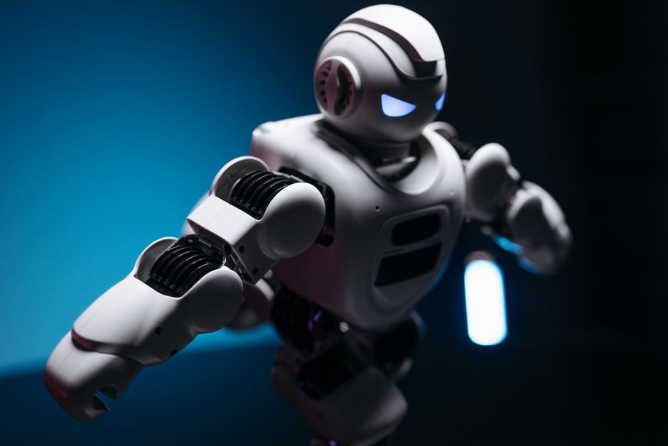 Dynamic shot of a futuristic robot with glowing eyes in a dark studio, showcasing innovation.