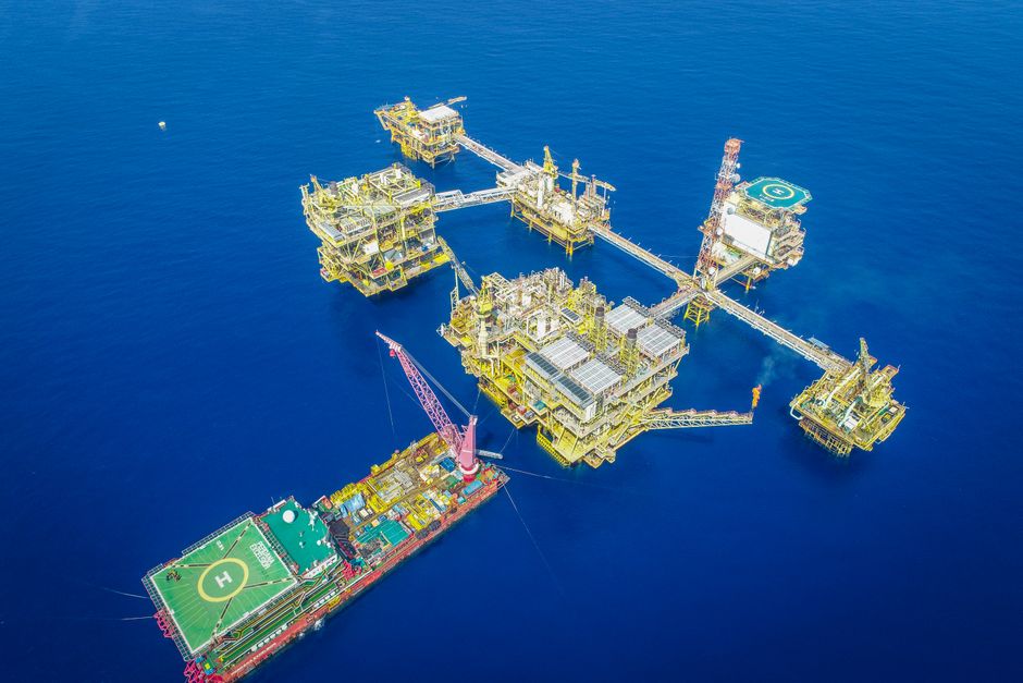 Aerial shot of an offshore oil platform complex in the ocean, showcasing industrial infrastructure.