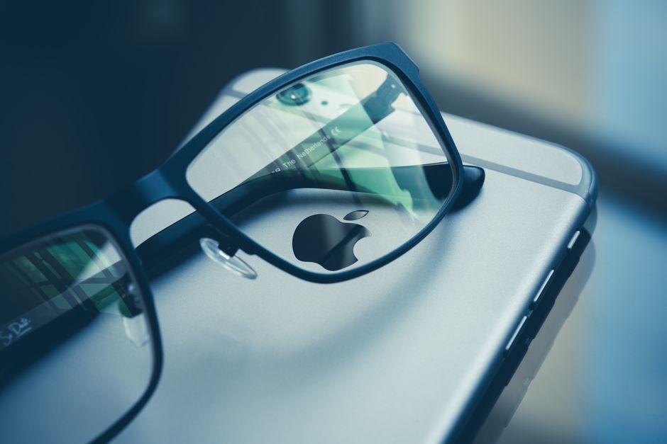 Close-up photo of eyeglasses placed over a smartphone, highlighting technology and style.