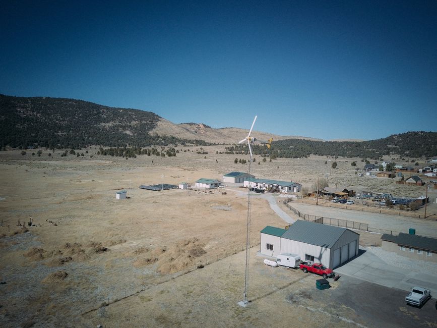 Aerial view capturing a wind turbine in a rural landscape, showcasing sustainable energy.