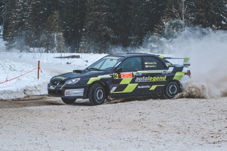 Exciting Subaru rally car racing through snowy Comandău, Romania, drifting across snow-covered tracks.