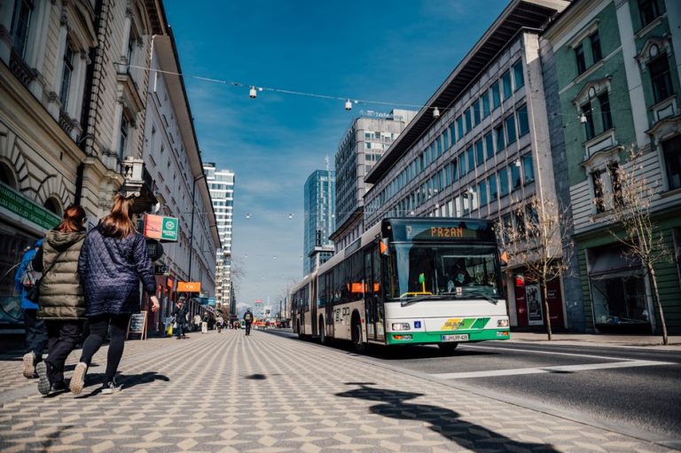 Street scene in Ljubljana featuring public transportation bus and pedestrians.