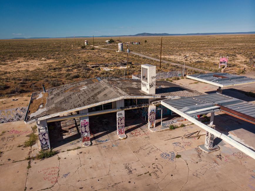 Aerial view of an abandoned, graffiti-covered gas station in the arid Arizona landscape. Ideal for concepts of decay and adventure.
