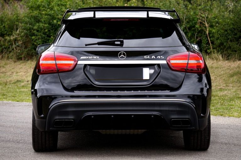 Rear view of a black Mercedes-Benz GLA 45 AMG parked outdoors, showcasing luxury and style.