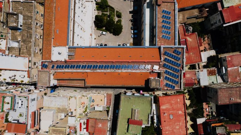 Aerial view of red-roofed urban buildings adorned with solar panels, Napoli, Italy.