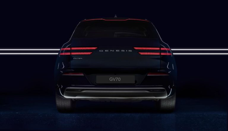 Rear view of a Genesis GV70 luxury SUV with illuminated lights, captured in a studio setting.