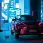 Stylish Lexus SUV parked at night, showcasing luxury in an urban landscape with vibrant neon lights.