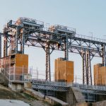 A large industrial hydroelectric facility captured in the serene light of sunset.