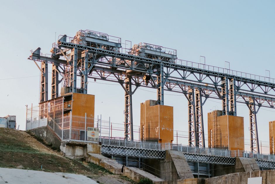 A large industrial hydroelectric facility captured in the serene light of sunset.