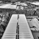 Black and white aerial shot of Hertfordshire warehouses and surrounding greenery.